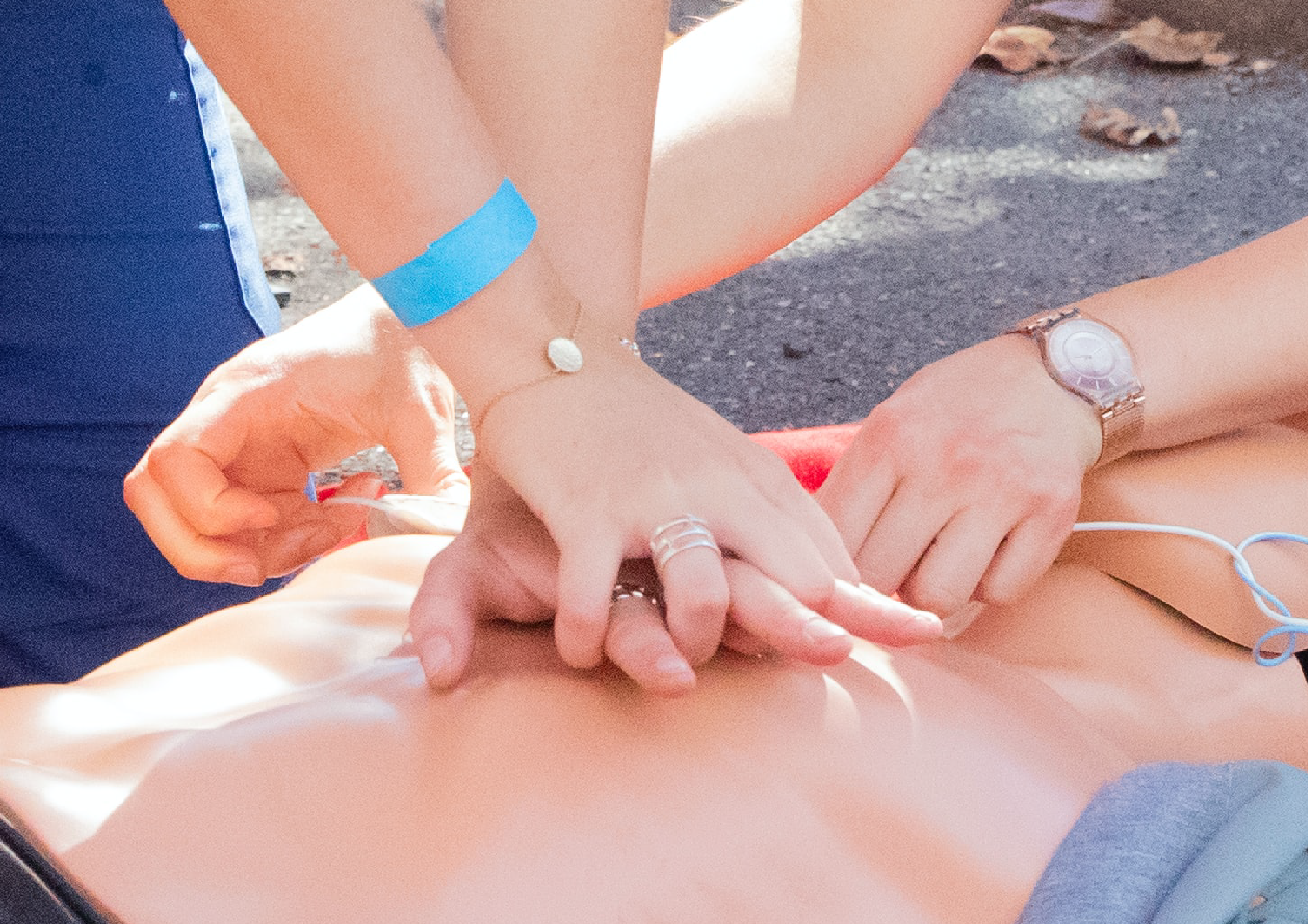Close up of hands performing first aid and CPR on an individual lying on the ground