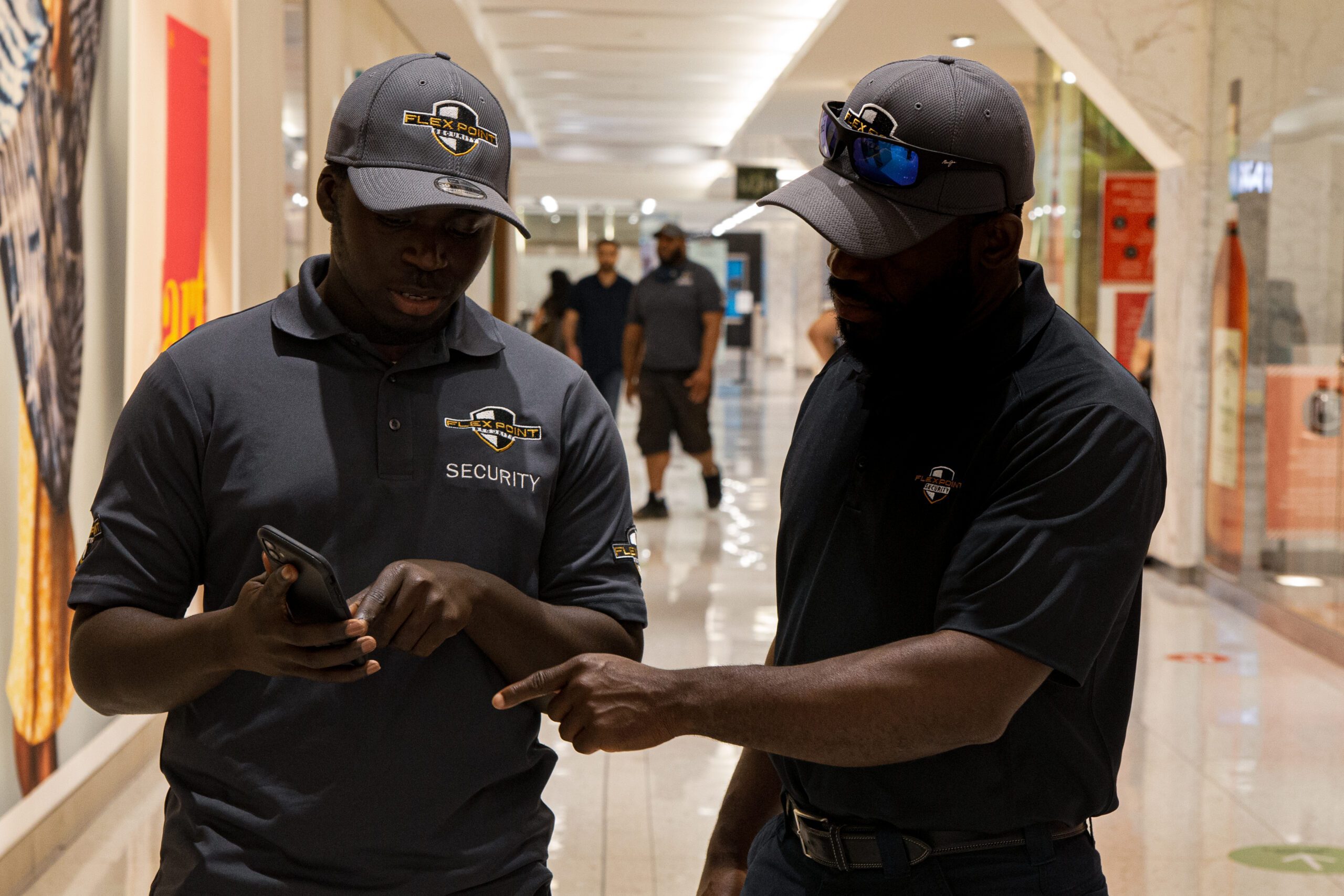 A Flex Point Security trainer showing a junior security guard in training information on a mobile device