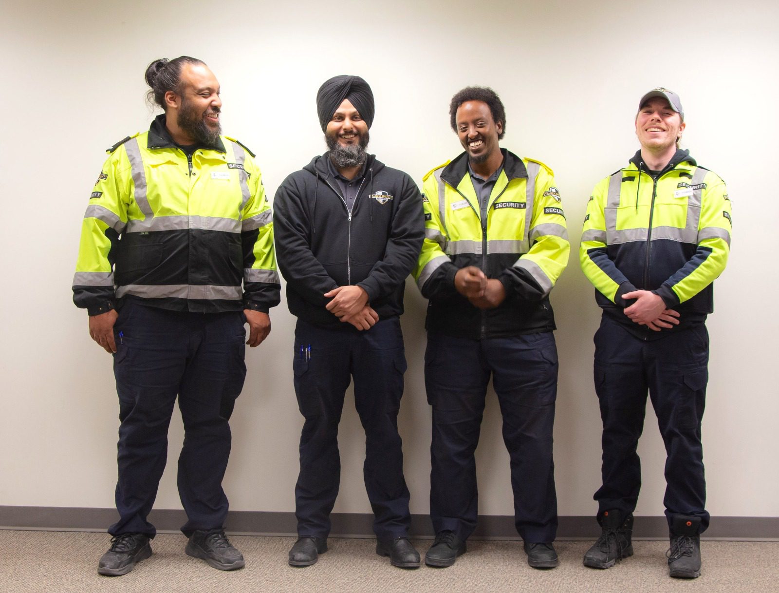 4 Flex Point Security team members standing and laughing as they pose for a picture