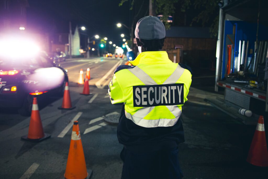 A Flex Point Security guard patrolling a construction site around a set of pylons