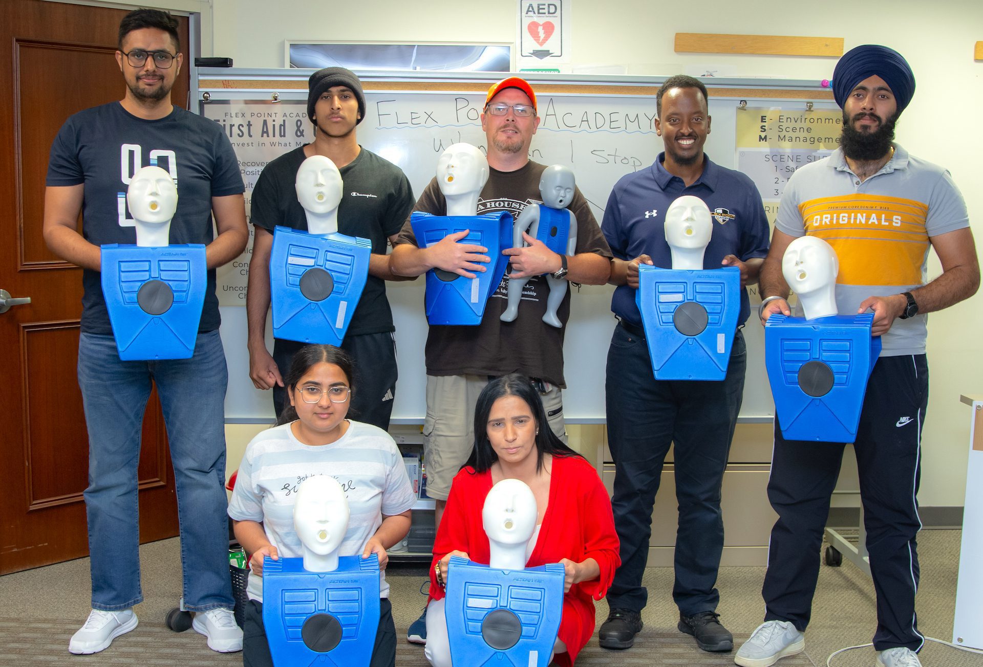First Aid and CPR training trainees standing and hold their blue dummy/mannequin that was used for training