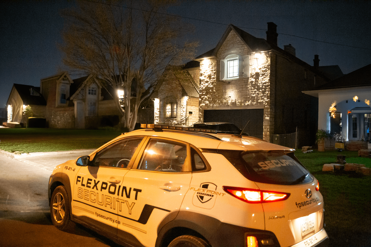 A white Flex Point Security vehicle patroling a neighbourhood at night