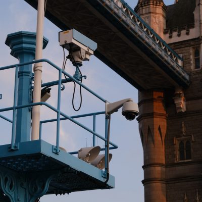Two CCTV cameras installed on a platform overlooking a building