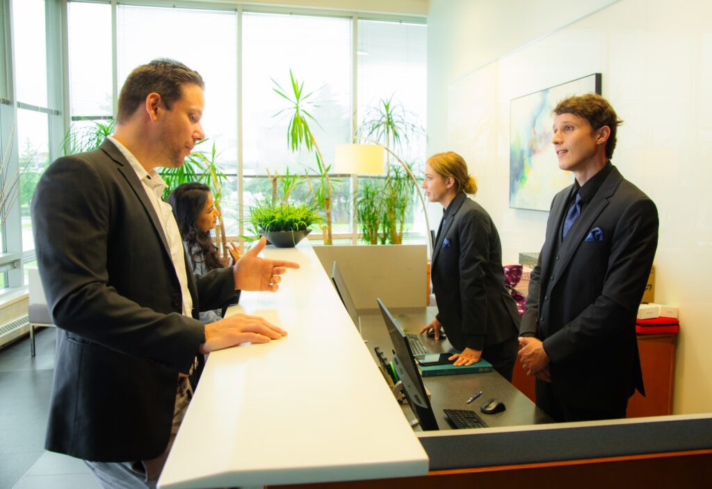 Two Flex Point Security male and female concierge service providers standing and speaking with building residents