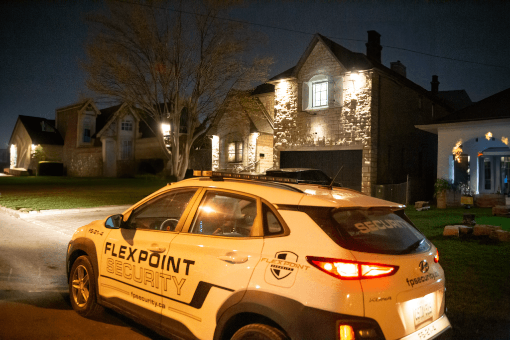 A white Flex Point Security vehicle patrolling a neighbourhood at night