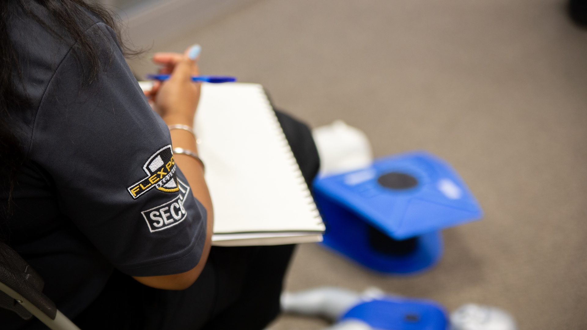 Close up of a female security guard trainee writing notes during first aid and CPR training